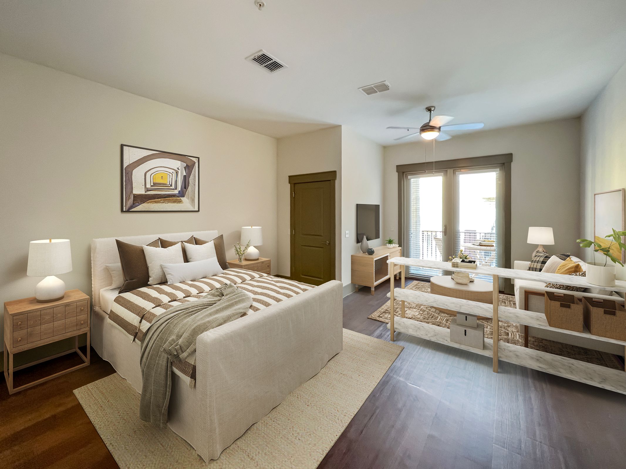 Sunny modern bedroom with a large bed, desk, and seating area, featuring neutral tones and wooden accents.